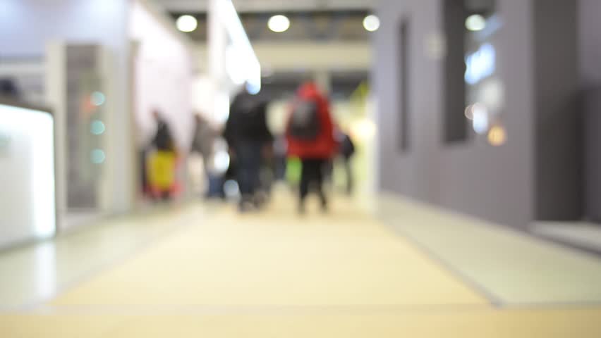 group of people walking down the hall, exhibition hall, business center, blurred view