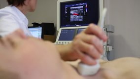 Doctor checks the thyroid using ultrasound, focus on display