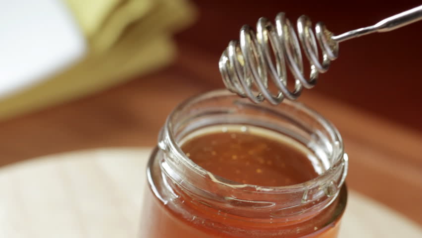 Clear honey in jar on table