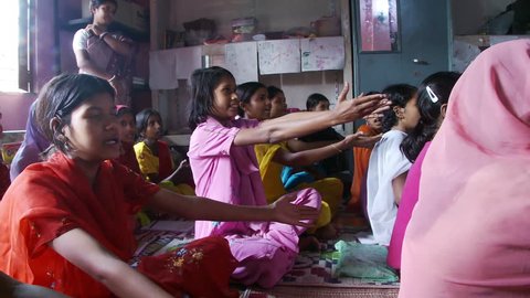 Baruipur, India - CIRCA 2013 - Girls in school sitting on mats singing and using hand gestures