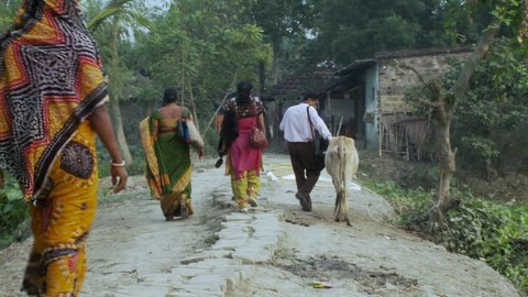 Baruipur, India - CIRCA 2013 - Villagers in India walking down dirt path