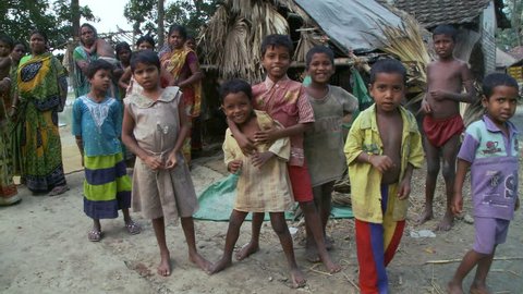 Baruipur, India - CIRCA 2013 - Eight children look at camera with mothers in the background
