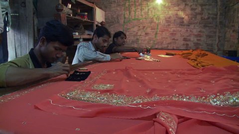 Baruipur, India - CIRCA 2013 - Indian men sewing sequins on cloth