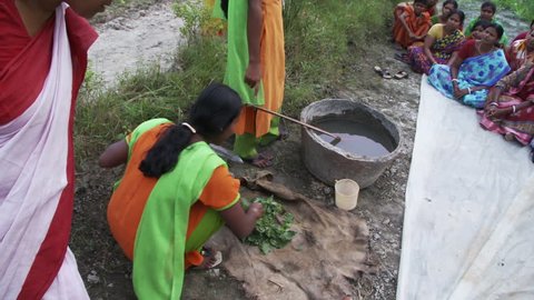 Baruipur, India - CIRCA 2013 - Girl teaching women sitting on ground learning about making fertilizer