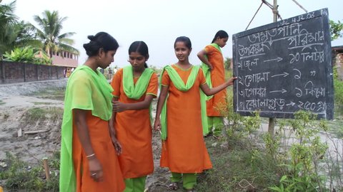 Baruipur, India - CIRCA 2013 - Girls explain how to make fertilizer at chalkboard