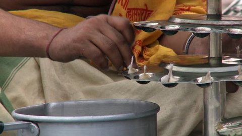 Varanasi, India - CIRCA 2013 - Closeup view of man preparing candles for Arti ceremony