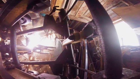 Man Welding a Snowmobile Frame at Home in a Workshop