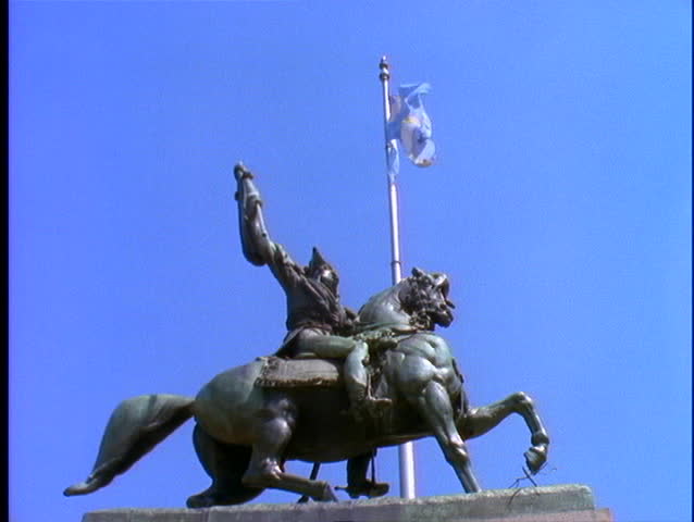 A flag flies behind a statue in Buenos Aires.