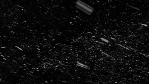 Falling down in slow motion real snowflakes from left to right, calm snow, shot on black background, matte, wide angle, seamless looped animation, isolated, perfect for digital composition