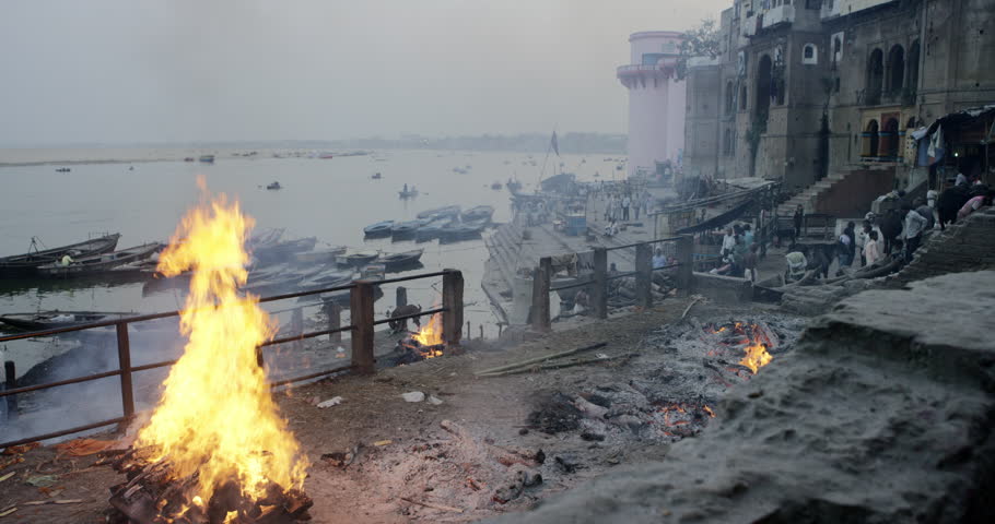 Varanasi, India - Cremation fire on Dasawamedha Ghat. Evening late afternoon Ganges river ghat people fire mystery smoke body temple ceremonies. Varanasi, India February 2016 | Shutterstock HD Video #14220362