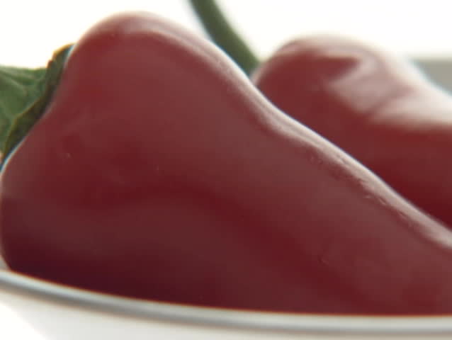 Red peppers sit in a small bowl.