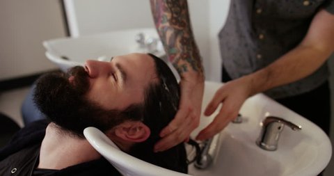 Shot of a young man having his hair washed at a hair salon. 
