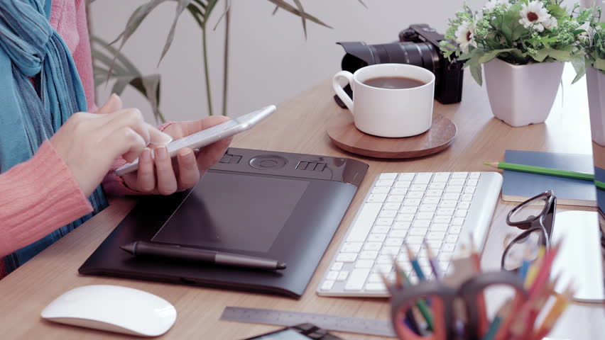 Young Caucasian female is distracted by her mobile phone during work