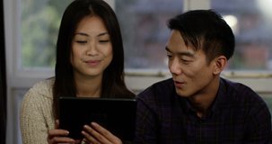 Young Asian couple having a video chat on their digital laptop. Shot on RED Epic.