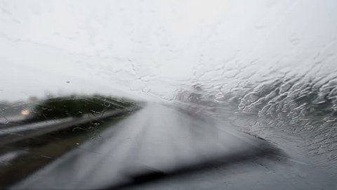 Car wipers removing heavy rain from the windshield during ride