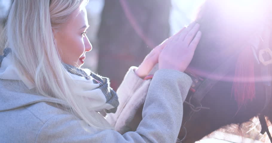 Beautiful blonde caucasian woman enjoying the sunny day with her horse
interaction people with animals