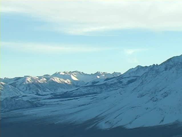 A zoom-out from snow covered mountains in the Eastern Sierras of California.