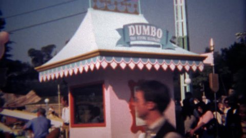 ANAHEIM, CALIFORNIA 1979: Disneyland Dumbo amusement park ride with dad and son.
