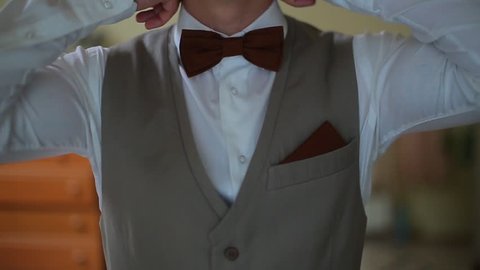 Man in the white shirt correcting bow-tie.