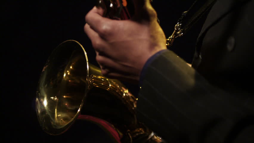 Jazz musicians play their instruments against a black background with colorful