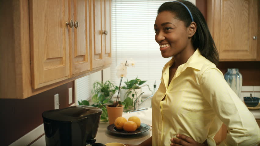 An African American woman performs various tasks around the house. She searches
