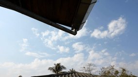 moving light clouds and blue sky timelapse, foreground as roof of the house