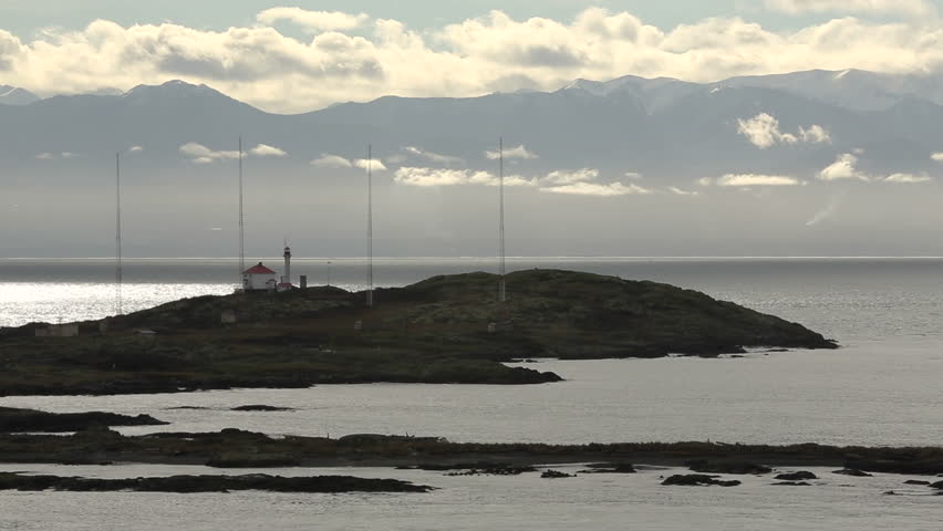 Trial Islands Lighthouse, Victoria. The lighthouse on the Trial Islands, near Victoria on Vancouver Island. The Olympic Mountain range, in Washington State, rises in the background.
