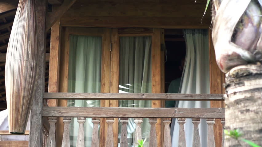 Young man walking out and stretching on terrace, super slow motion 120fps
