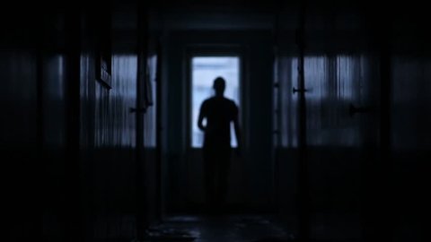 Shot of male inline walking along hostel corridor, static camera