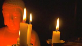 Candlesticks with burning candles in the darkness over a white porcelain statuette of Buddha and a wooden box / camera moving forwards and stops - Powered by Shutterstock - Get 15% off with code: PIKWIZARD15
