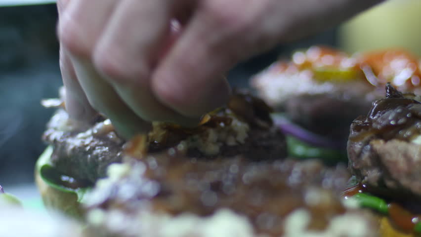 Cooking hamburger - ingredients are buns vegetables and grilled meat