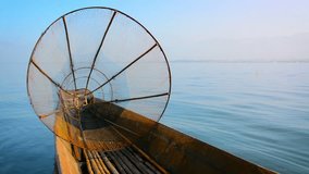 Traditional. handmade. conical fishing net is the only cargo on a wooden canoe floating on Inle Lake in Myanmar. FullHD video