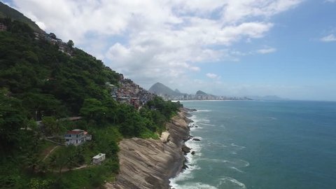 Flight view close to a mountain and approaching the Morro do Vidigal road with a beautiful view of the rocks, the sea and the beach of Ipanema and its building. Summer Rio de Janeiro 2016 Olympic City