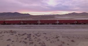 Sunset Train Boxcars Combo / Contains 2 clips. One is an aerial flight panning at train boxcars with the sunsetting in the background. The second is flying over the train of boxcars.