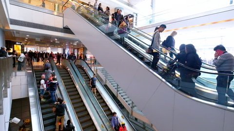 HONG KONG - JAN 18, 2015: People on moving escalators at modern shopping mall