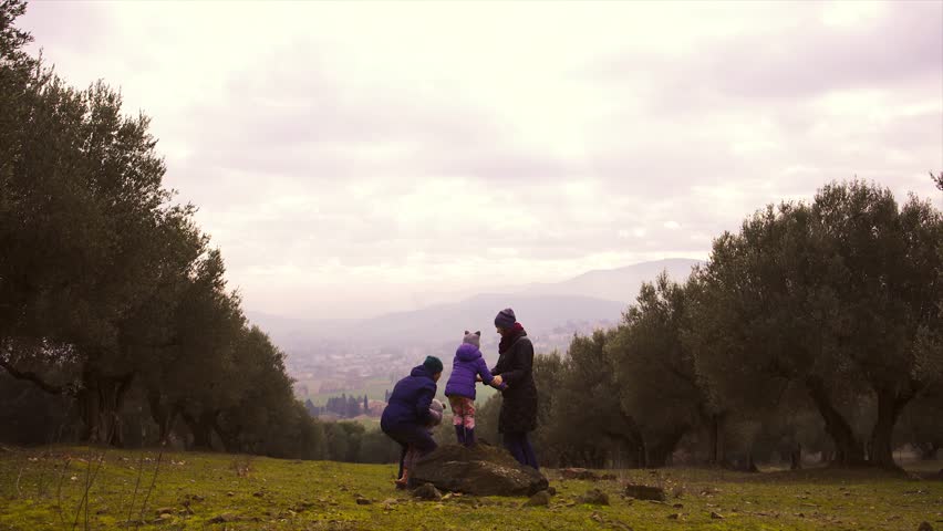 Family with two little children having fun in autumn garden