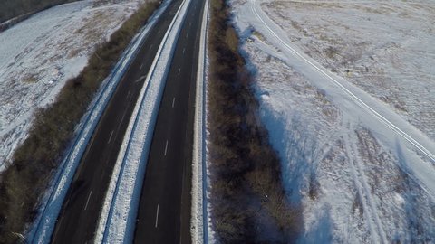 Flight over Cars ride on road in winter snowy forest, AERIAL View