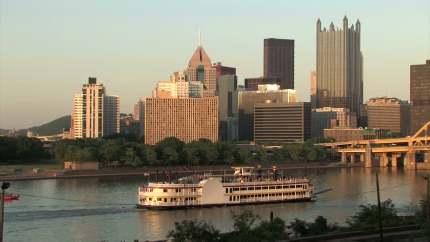 A large riverboat passes by downtown Pittsburgh on the Monongahela River.  All