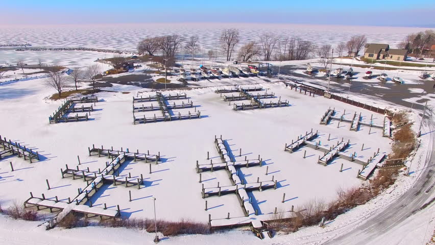 Frozen harbor, marina in winter, Wisconsin, Aerial Flyover.

