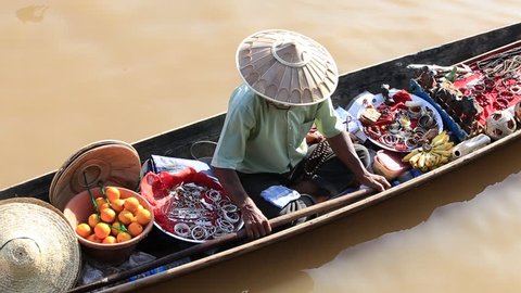 INLE LAKE, MYANMAR - JANUARY 14, 2016 : Unidentified Burmese man on small long wooden boat selling souvenirs, trinkets and bijouterieat the floating market on Inle Lake, Myanmar