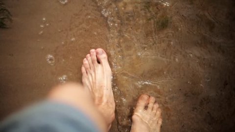 Man walk on sand beach, waves gentle wash his feet. Summer. First person view