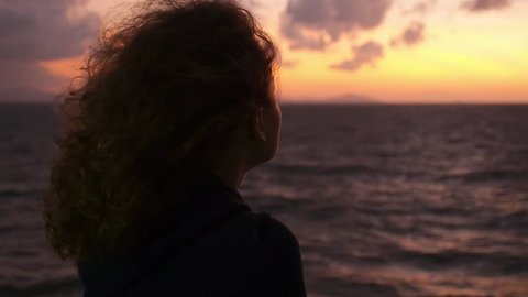 Thoughtful Young Woman Enjoying Sunrise at Sea