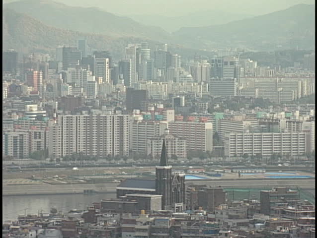 A neighborhood sits across the bay from a city skyline.