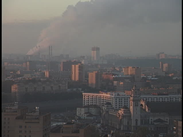 Smoke and smog cover the sky above a crowded city.