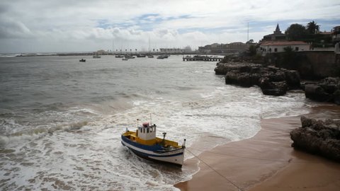 PORTUGAL - CIRCA OCTOBER 2015 - Fishing boat stuck on Atlantic ocean coast beach, Cascais marina, Portugal