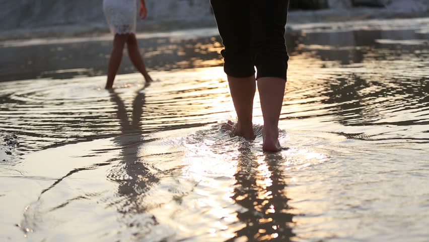 Young pair walking on beach barefoot over sunset and enjoying nature.  | Shutterstock HD Video #14361778