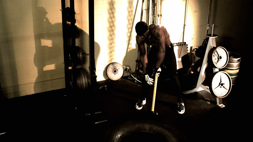 A muscular African male works out. Footage provided in both an extreme color