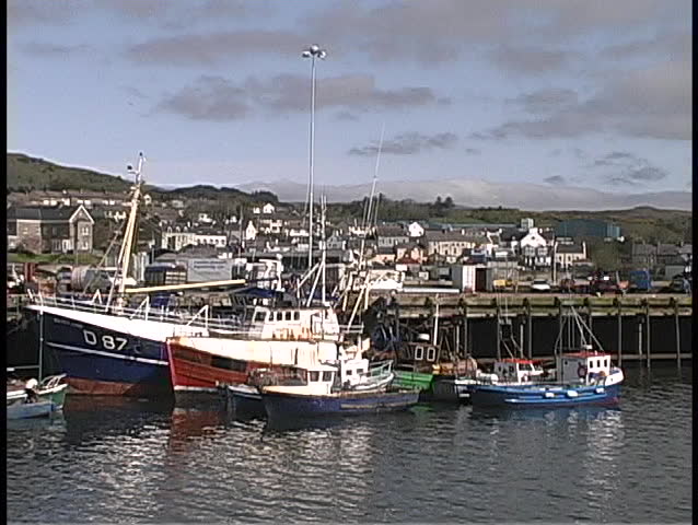 Ships and boats float in an Irish harbor.