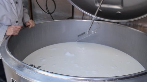 Industry Woman worker in milk factory, the cauldron of milk