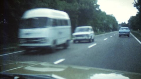 CIRCA 1968: Vintage 8mm film of a highway with old cars driving around